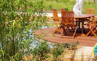 terrasse ronde sur un étang avec mobilier en bois