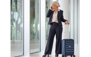 femme au téléphone avec sac de voyage