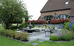 grand jardin avec fontaine et terrasse pavée