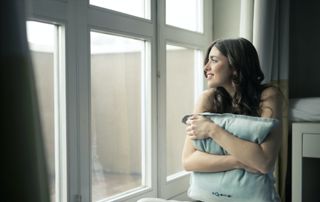 jeune femme regardant par la fenêtre
