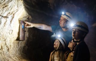 Visiteurs dans la grotte avec des lampes frontales