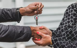 homme qui tient une clé tout en tenant les mains d'une femme